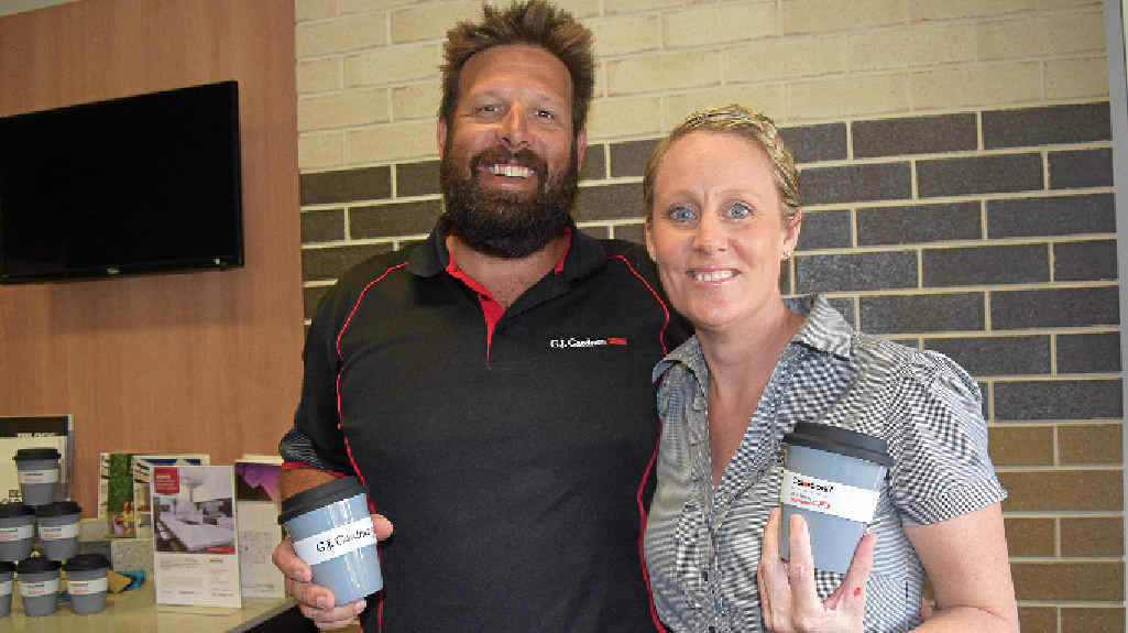 HELPING OUT: Jono and Lisa Moir, owners of GJ Gardner, have made the special Airlie Beach Triathlon mugs.